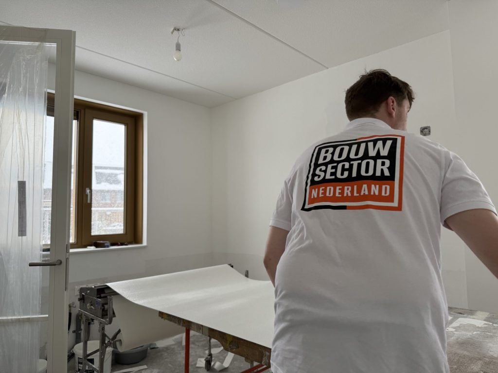 Behanger van Bouwsector Nederland bij de plaktafel in een afgedekte kamer